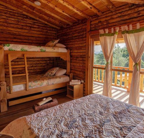 a bedroom with two bunk beds in a log cabin at NIGUITO HOTEL in Santa Elena