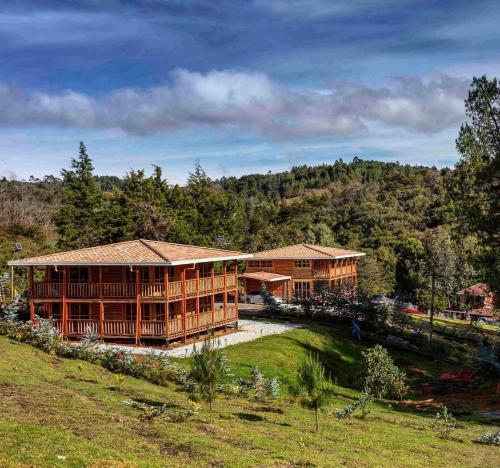 a large wooden building on a hill with trees at NIGUITO HOTEL in Santa Elena