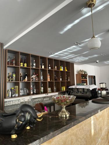 a kitchen with a bar with a counter with a vase of flowers at 4 Stinët in Valbonë
