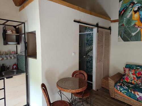 a small room with a table and chairs and a kitchen at La petite tanière in Fontan