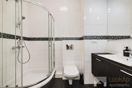 a bathroom with a shower and a toilet and a sink at Ilumino Prestige by LookAp - Centrum in Łódź