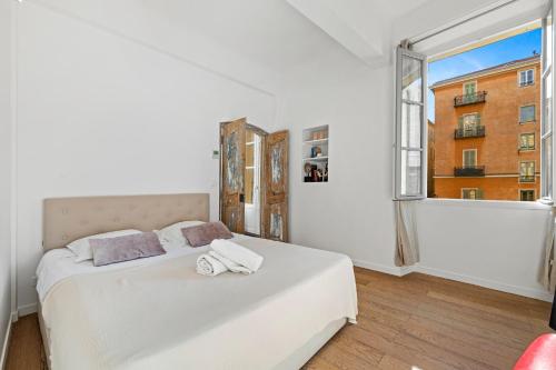 - une chambre blanche avec un lit et une fenêtre dans l'établissement MAGIC CATHEDRALE, à Nice