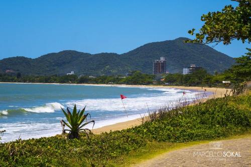 a beach with a red flag and the ocean at Casa da Dinda in Penha