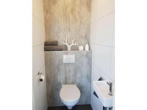 a bathroom with a toilet and a sink at Holiday home Chalet 79 in Olburgen