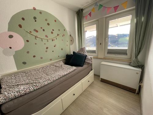 a bedroom with a bed and a wall with polka dots at Ferienwohnung Dorfblick mit 2 SZ, Balkon und Ski- oder eBike Keller in Winterberg