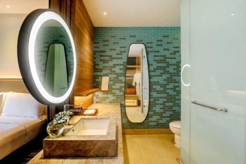 a bathroom with a sink and a bed and a mirror at Holiday Inn Resort Samui Bophut Beach by IHG in Bophut 