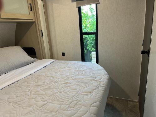 a bed in a room with a window at Free BBQ in RV With Private entrance in Homestead