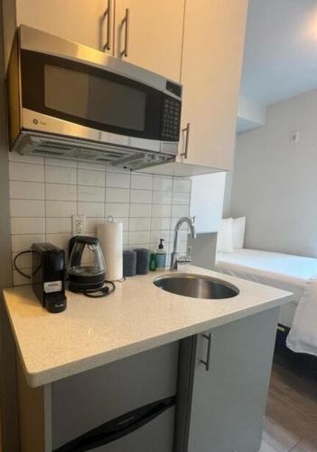 a kitchen counter with a sink and a microwave at Salmonberry Studio in Wallingford - 97 Walkscore! in Seattle