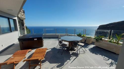 a balcony with a table and chairs and the ocean at Castelo do Mar, Madeira in Tábua