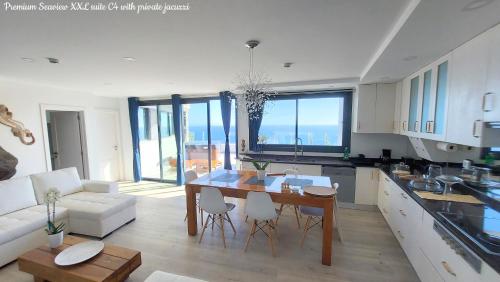 a kitchen and living room with a table and chairs at Castelo do Mar, Madeira in Tábua