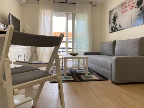 a living room with a couch and a chair at Espacioso Apartamento Familiar con terraza en Aranjuez - Confort, Tranquilidad y Netflix Incluido in Aranjuez