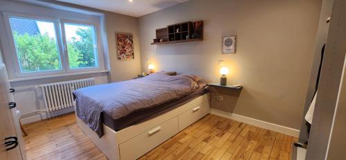 - une petite chambre avec un lit et deux lampes dans l'établissement Logement 100m² industriel avec jardin et terrasse, à Brumath