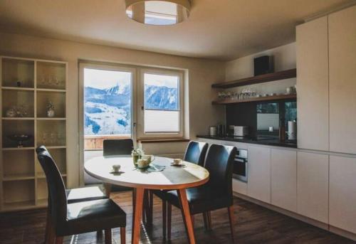 a kitchen with a table and chairs with a mountain view at Chalet zum Wohlfühlen in Ramsau am Dachstein
