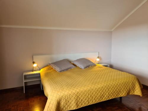 ポンタ・デルガダにあるGorgeous Houseのベッドルーム1室(黄色のベッド1台、ランプ2つ付)