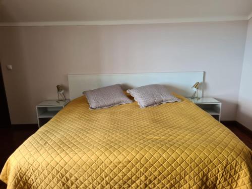 a bedroom with a yellow bed with two tables at Gorgeous House in Ponta Delgada