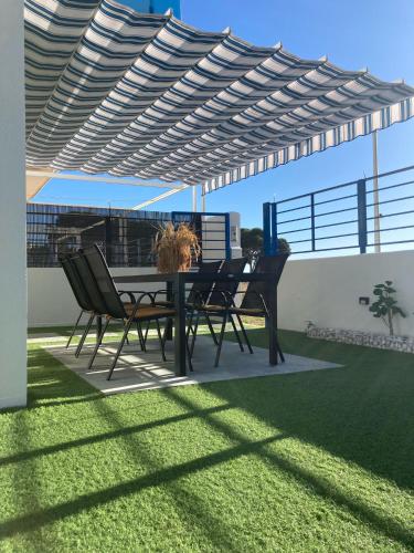 a table and chairs under a pergola on a patio at Casa Sete in Alcanar