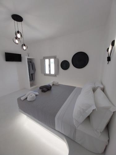 a white bedroom with a bed in a white room at East Wind Perissa in Perissa