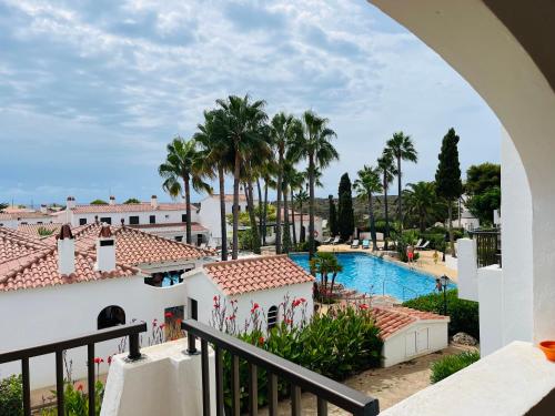 a view of the pool from the balcony of a resort at Precioso apartamento piscinas Cala en Porter in Cala'n Porter