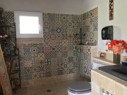 La salle de bains est pourvue de toilettes, d'une fenêtre et de carrelage. dans l'établissement Magnifique villa avec piscine Mt Ventoux Provence, à Carpentras