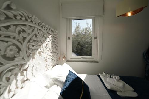 a bedroom with a white bed with a window at Mazzarò Luxury Apartment Taormina in Taormina