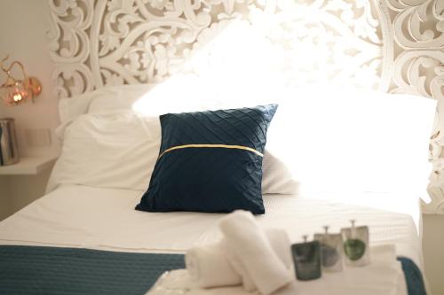 a bed with a blue pillow on top of it at Mazzarò Luxury Apartment Taormina in Taormina