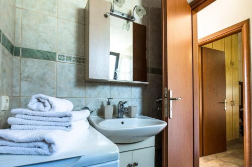 bagno con lavandino, specchio e asciugamani di Zouri Apartments a Kíssamos