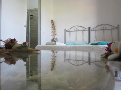 a bedroom with a bed and a glass table at Agriturismo Tenuta Pozzello in Torre dell'Orso