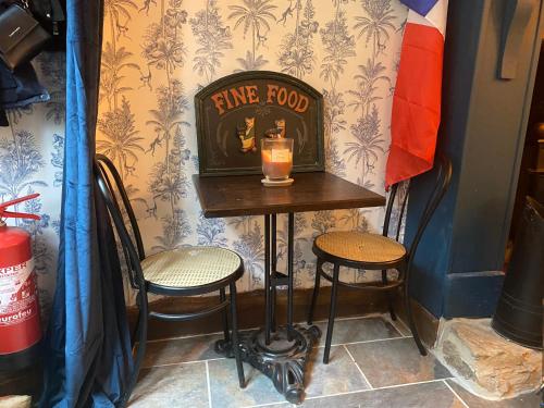 a small table with two chairs and a drink on it at Moon River Bellac Chambre d'hotes in Bellac