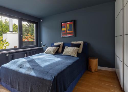 Dormitorio azul con cama y ventana en Appartement Waldheim, en Bad Nauheim