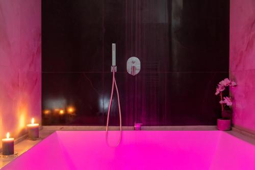 a pink bath tub with two candles in a bathroom at MAIN - Duomo in Naples