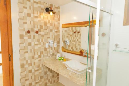 a bathroom with a sink and a shower at Pousada das Bromélias in Ipiabas
