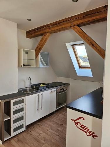 eine Küche mit weißen Schränken und einem Dachfenster in der Unterkunft Apartment Home 3 in Schwabach