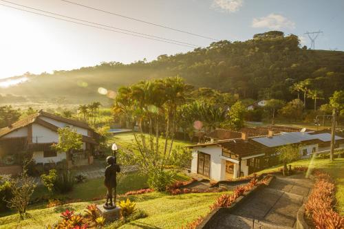 a man standing on a street light in front of a house at Pousada das Bromélias in Ipiabas