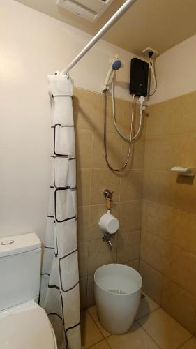a bathroom with a shower and a toilet at J Studio - Fast WiFi, 55" UHD TV with Netflix & Prime Video, Free Pool Access in Silang
