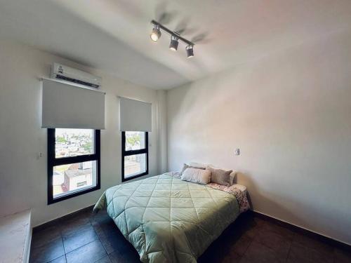 a bedroom with a bed and two windows at Depto en Buenos Aires, Ciudadela. in Ciudadela