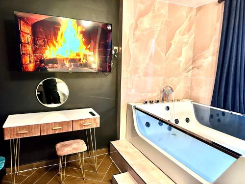 a bathroom with a fireplace with a tub and a tv at G Eighty Four in London