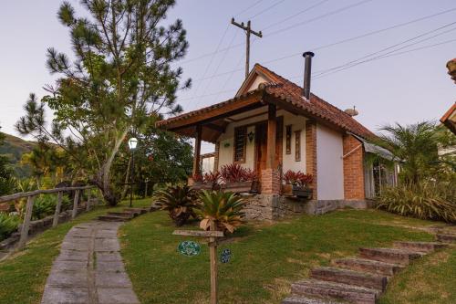 a small house with stairs leading to it at Pousada das Bromélias in Ipiabas
