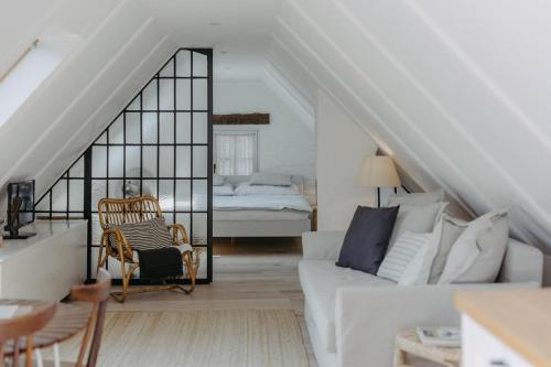 uma sala de estar com um sofá branco e uma cama em Streckhof Stiefelgasse 3 em Purbach am Neusiedlersee