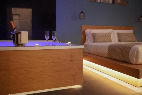a bedroom with a bed and two glasses of wine at MAIN - Duomo in Naples