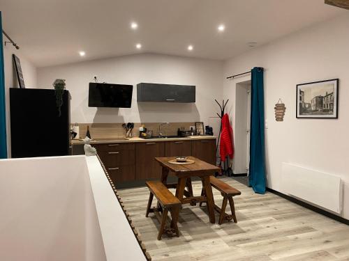 une cuisine avec une table en bois et une petite table dans l'établissement Maisonnette 2/4 personnes en bord de sevre, à Cugand