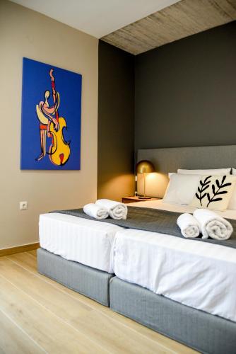 a bedroom with a bed with a guitar on the wall at Ambient Living Lofts in Preveza