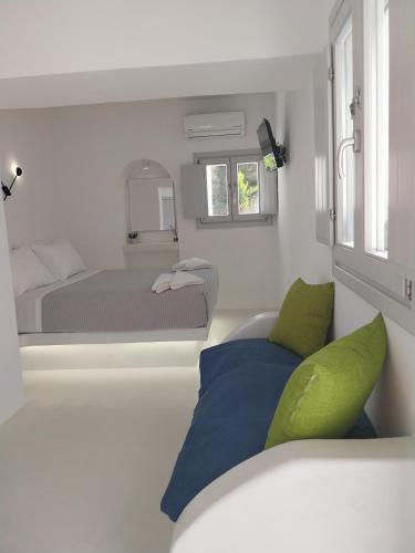 a small bedroom with a bed and a couch at East Wind Perissa in Perissa