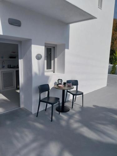 a patio with two chairs and a table in a room at East Wind Perissa in Perissa