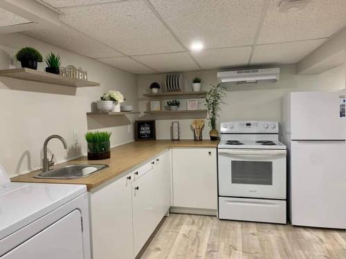 a kitchen with white cabinets and a white stove at Ting’s Place - Luxury suite in Campbellton