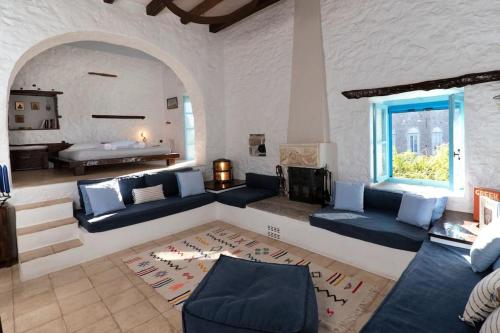 a large living room with blue couches and a window at Historical Stone Manor-Upper floor in Hydra