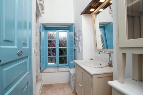a bathroom with a blue door and a sink at Historical Stone Manor-Upper floor in Hydra