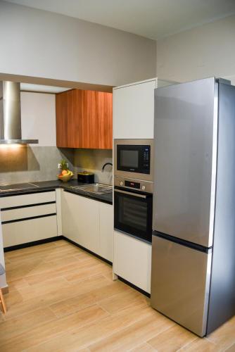 a large kitchen with a stainless steel refrigerator at Ambient Living Lofts in Preveza