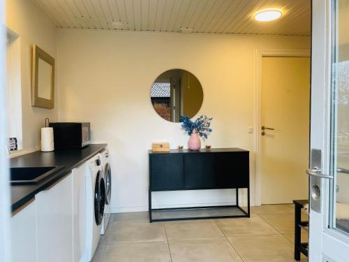 a laundry room with a washing machine and a mirror at 1 private room in Billund in Billund