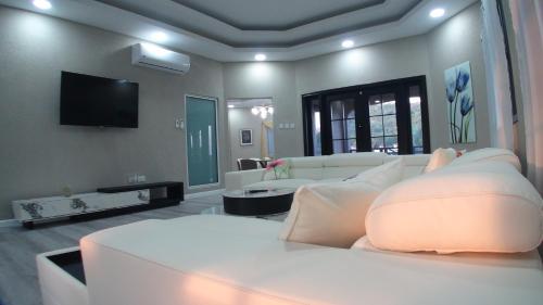 a living room with white furniture and a flat screen tv at Golden Pear Villa-CR in Confer