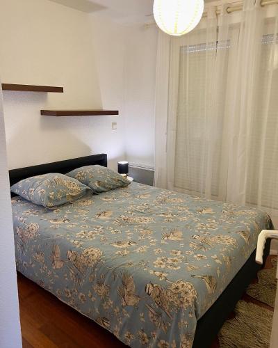 une chambre avec un lit avec une couette bleue dans l'établissement Proche Gare d'Annemasse, Genève, à Ville-la-Grand